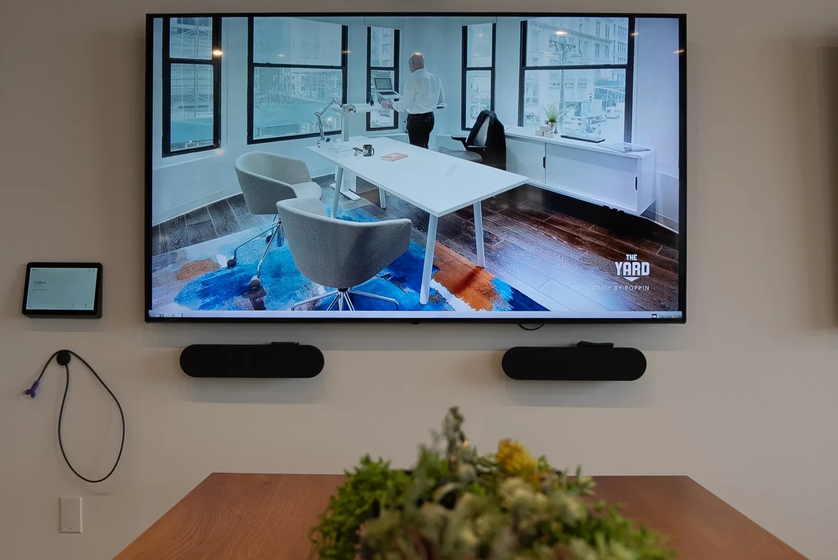 Wall-mounted commercial display driven by a small media player, showing signage content in a dealership space