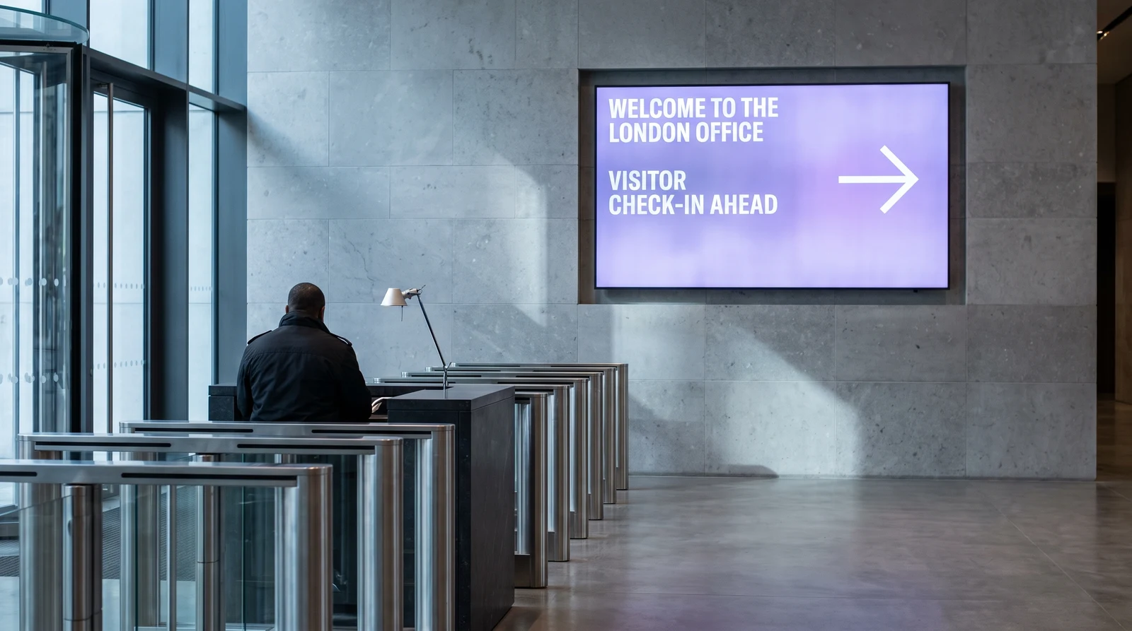 Office reception lobby with a digital signage screen greeting arriving visitors