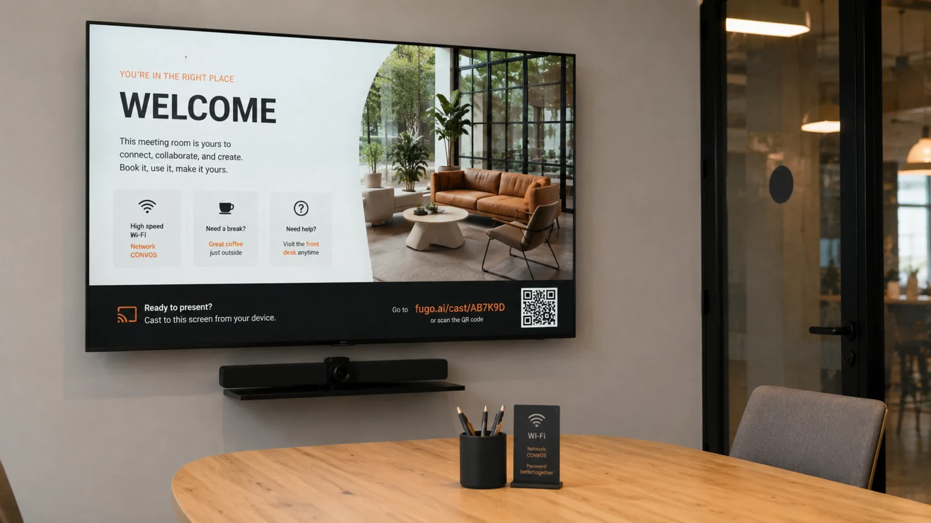 Meeting-room display running a Fugo welcome screen with a casting link and QR code, browser-based playback in a coworking space