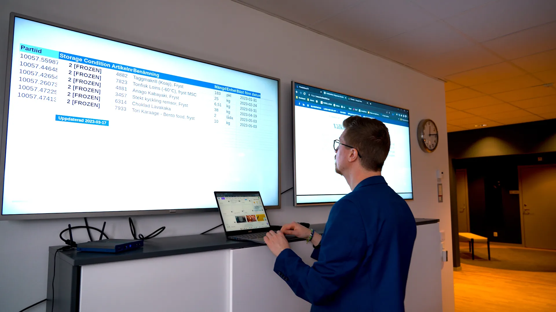 Call center floor with wall-mounted displays showing live queue metrics and agent performance dashboards
