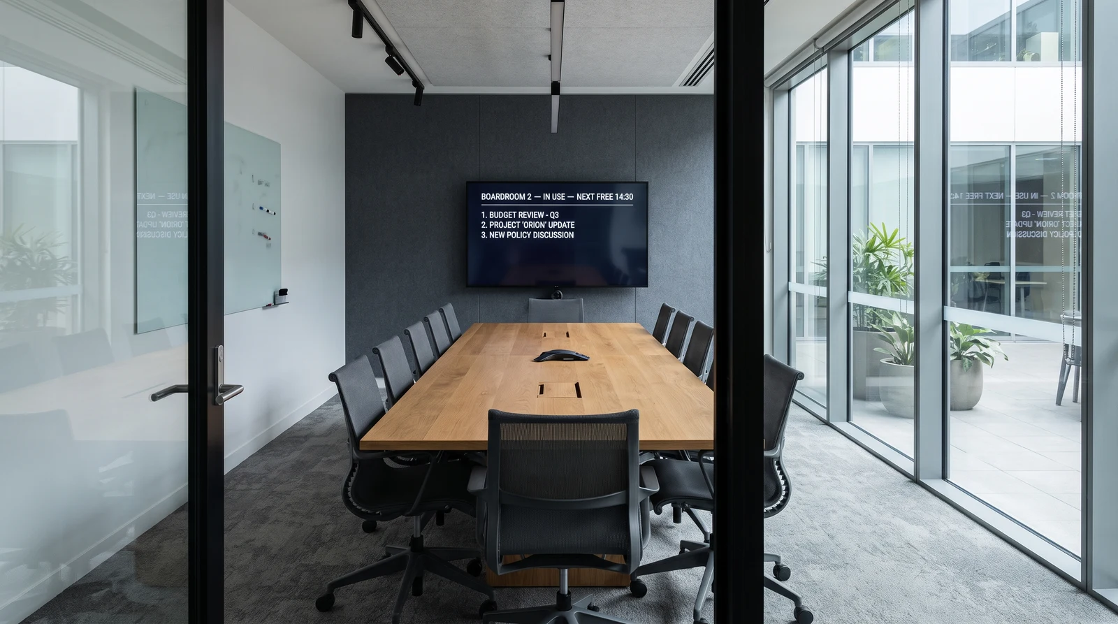 Boardroom wall display showing room status, next free time and the meeting agenda