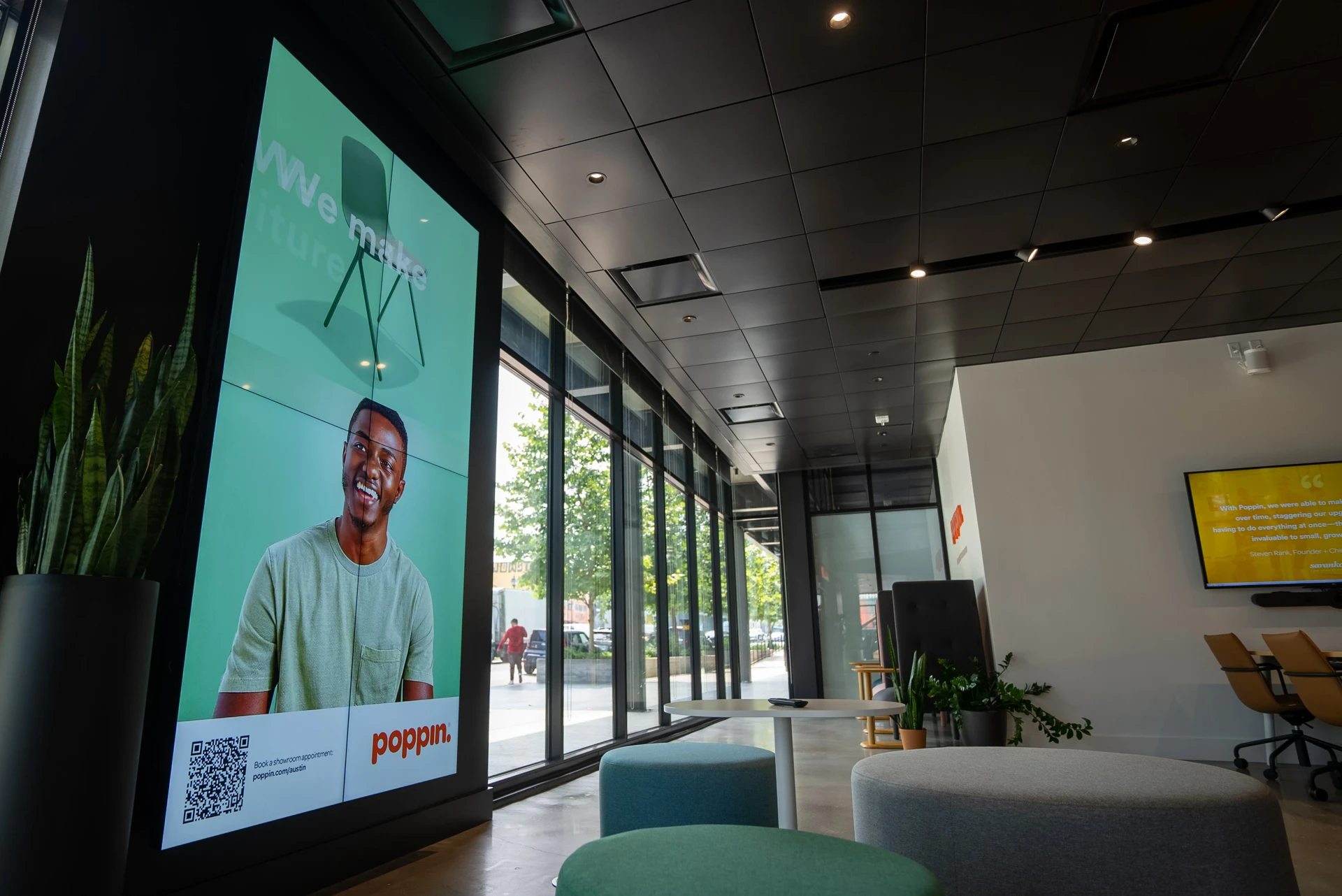 Poppin office lobby portrait video wall displaying a branded campaign with QR code