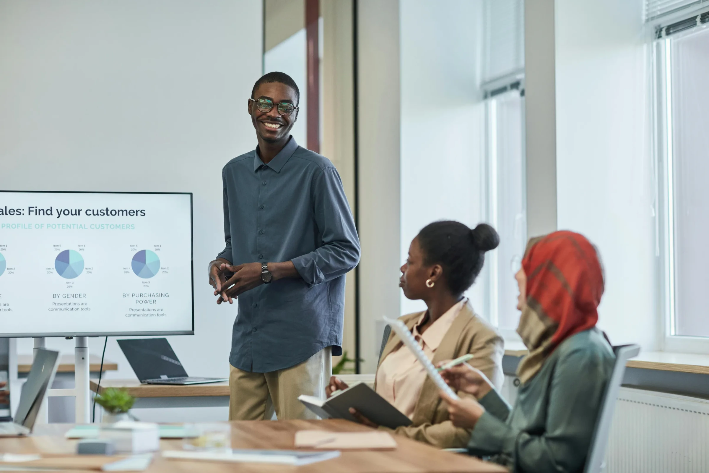 Sales team presentation with a customer-segmentation dashboard displayed on a TV